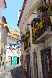 Rue et maisons colorées avec guirlandes fenêtres quartier du château Lisbonne.