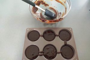 Préparation de fondant au chocolat versée dans les moules.