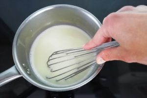Mélange du lait dans la casserole avec sucre et maïzena.