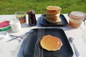 Petit déjeuner au soleil avec des pancakes et de la confiture maison