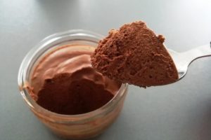 Cuillère et petit pot de mousse au chocolat végétale sans oeufs, au jus de pois chiche.