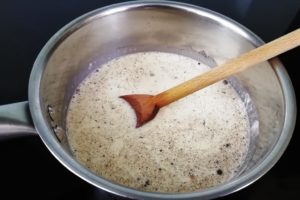 Casserole avec le lait, la crème et la gousse de vanille fendue