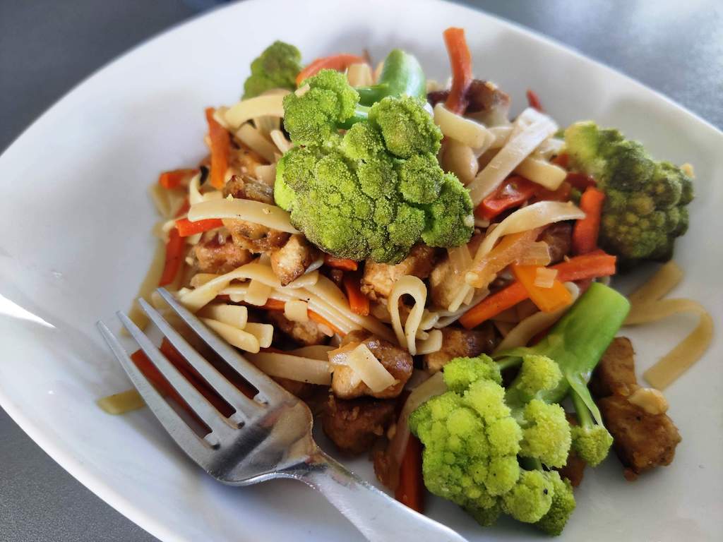 Assiette de nouilles aux légumes et tofu prête à être mangée