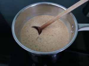 Casserole avec le lait, la crème et les spéculoos après mélange