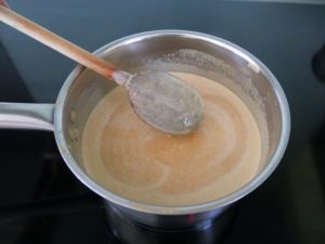 Mélange qui nappe la cuillère en bois au dessus de la casserole