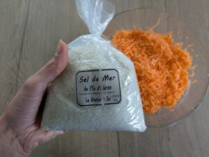 Paquet de sel de mer et derrière un saladier de carottes